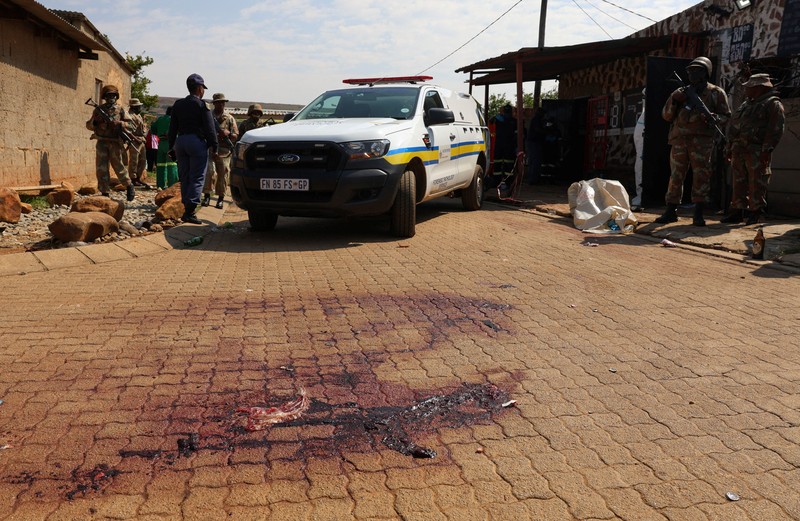 Blood stains on the ground next to an emergency vehicle at the site of a deadly shooting at a tavern in Wedela township, southwest of Johannesburg, South Africa, September 27, 2026. REUTERS/Oupa Nkosi