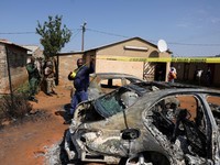 Emergency personnel cordon off an area next to burnt vehicles at the site of a deadly shooting at a tavern in Wedela township, southwest of Johannesburg, South Africa, September 27, 2026. REUTERS/Oupa Nkosi     TPX IMAGES OF THE DAY