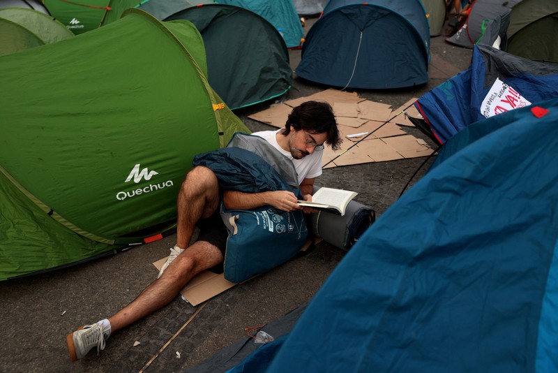 Para demonstran tidur dan berkumpul di sekitar tenda setelah mendirikan perkemahan di alun-alun Puerta del Sol sebagai protes terhadap krisis perumahan di Spanyol menyusul penggusuran paksa seorang wanita berusia 87 tahun dari apartemennya di Madrid, Spanyol, 27 September 2026. REUTERS/Susana Vera