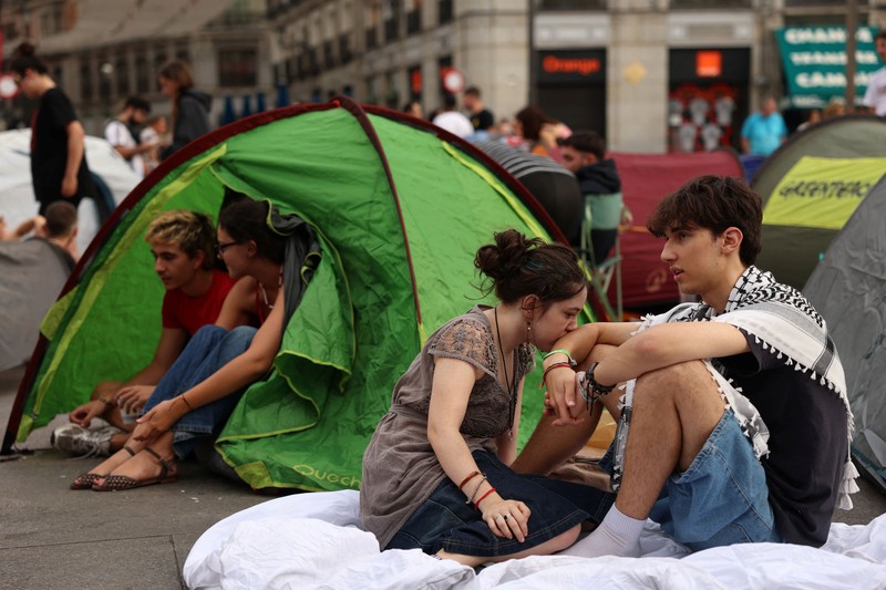 Para demonstran tidur dan berkumpul di sekitar tenda setelah mendirikan perkemahan di alun-alun Puerta del Sol sebagai protes terhadap krisis perumahan di Spanyol menyusul penggusuran paksa seorang wanita berusia 87 tahun dari apartemennya di Madrid, Spanyol, 27 September 2026. REUTERS/Susana Vera
