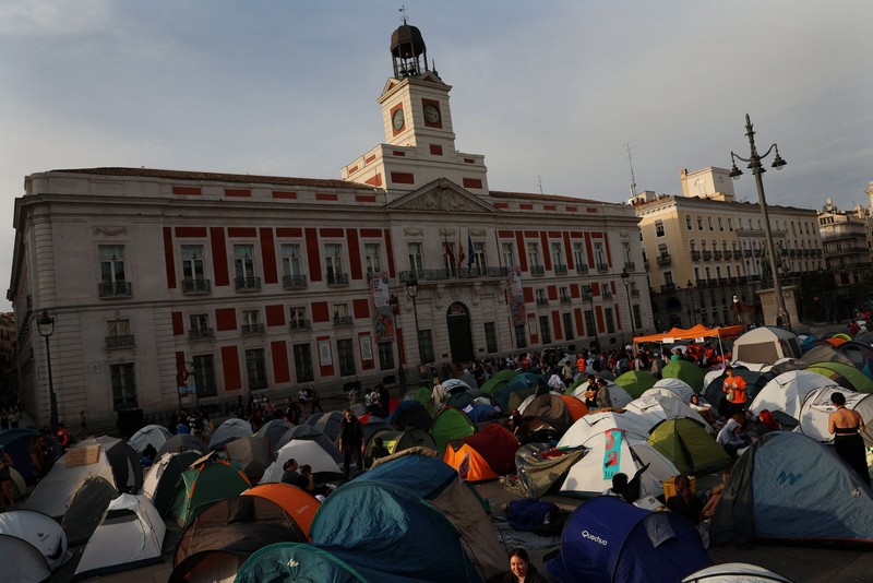 Para demonstran tidur dan berkumpul di sekitar tenda setelah mendirikan perkemahan di alun-alun Puerta del Sol sebagai protes terhadap krisis perumahan di Spanyol menyusul penggusuran paksa seorang wanita berusia 87 tahun dari apartemennya di Madrid, Spanyol, 27 September 2026. REUTERS/Susana Vera