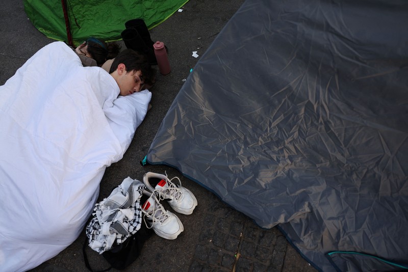Para demonstran tidur dan berkumpul di sekitar tenda setelah mendirikan perkemahan di alun-alun Puerta del Sol sebagai protes terhadap krisis perumahan di Spanyol menyusul penggusuran paksa seorang wanita berusia 87 tahun dari apartemennya di Madrid, Spanyol, 27 September 2026. REUTERS/Susana Vera