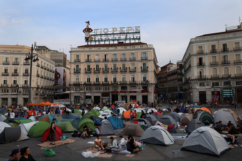 Para demonstran tidur dan berkumpul di sekitar tenda setelah mendirikan perkemahan di alun-alun Puerta del Sol sebagai protes terhadap krisis perumahan di Spanyol menyusul penggusuran paksa seorang wanita berusia 87 tahun dari apartemennya di Madrid, Spanyol, 27 September 2026. REUTERS/Susana Vera
