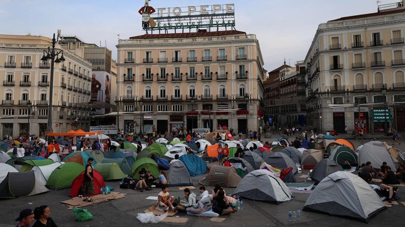 Para demonstran tidur dan berkumpul di sekitar tenda setelah mendirikan perkemahan di alun-alun Puerta del Sol sebagai protes terhadap krisis perumahan di Spanyol menyusul penggusuran paksa seorang wanita berusia 87 tahun dari apartemennya di Madrid,