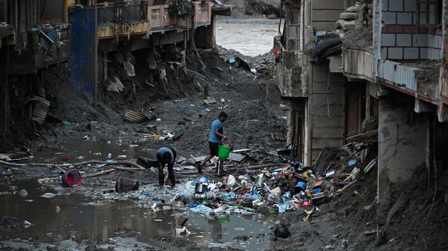 Foto udara memperlihatkan warga sedang menyelamatkan barang-barang dari tumpukan lumpur di dekat rumah-rumah yang terendam banjir bandang tanggal 26 Agustus, di dekat Sungai Trishuli di Devighat, Distrik Nuwakot, Nepal, pada 26 September 2026. (AFP/P