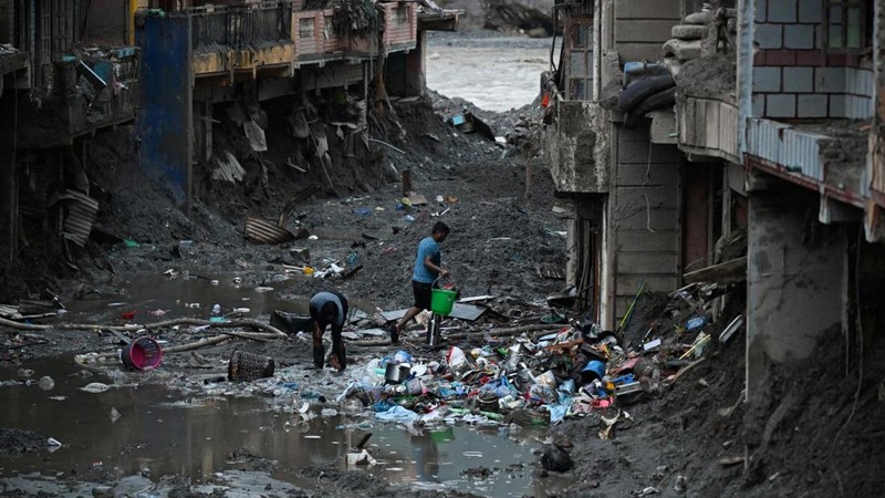 Foto udara memperlihatkan warga sedang menyelamatkan barang-barang dari tumpukan lumpur di dekat rumah-rumah yang terendam banjir bandang tanggal 26 Agustus, di dekat Sungai Trishuli di Devighat, Distrik Nuwakot, Nepal, pada 26 September 2026. (AFP/P