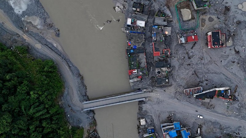 Foto udara memperlihatkan warga sedang menyelamatkan barang-barang dari tumpukan lumpur di dekat rumah-rumah yang terendam banjir bandang tanggal 26 Agustus, di dekat Sungai Trishuli di Devighat, Distrik Nuwakot, Nepal, pada 26 September 2026. (AFP/P