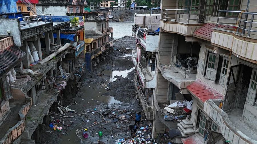 Foto udara memperlihatkan warga sedang menyelamatkan barang-barang dari tumpukan lumpur di dekat rumah-rumah yang terendam banjir bandang tanggal 26 Agustus, di dekat Sungai Trishuli di Devighat, Distrik Nuwakot, Nepal, pada 26 September 2026. (AFP/P