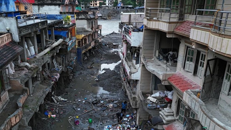 Foto udara memperlihatkan warga sedang menyelamatkan barang-barang dari tumpukan lumpur di dekat rumah-rumah yang terendam banjir bandang tanggal 26 Agustus, di dekat Sungai Trishuli di Devighat, Distrik Nuwakot, Nepal, pada 26 September 2026. (AFP/P