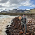 Taylor Evinger, seorang kandidat doktor di UC Davis, memegang botol berisi air berwarna oranye yang diambil dari Sungai Igning di Gates of the Arctic National Park and Preserve, Alaska. (Dokumentasi: Taylor Evinger/UC Davis)