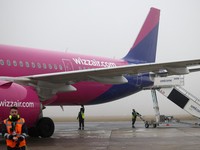 FILE PHOTO: Ground handling workers operate around a Wizz Air Airbus A321neo aircraft, registration 9H-WMI, at Warsaw-Modlin Airport in Modlin, Poland, December 1, 2025. REUTERS/Kacper Pempel/File Photo