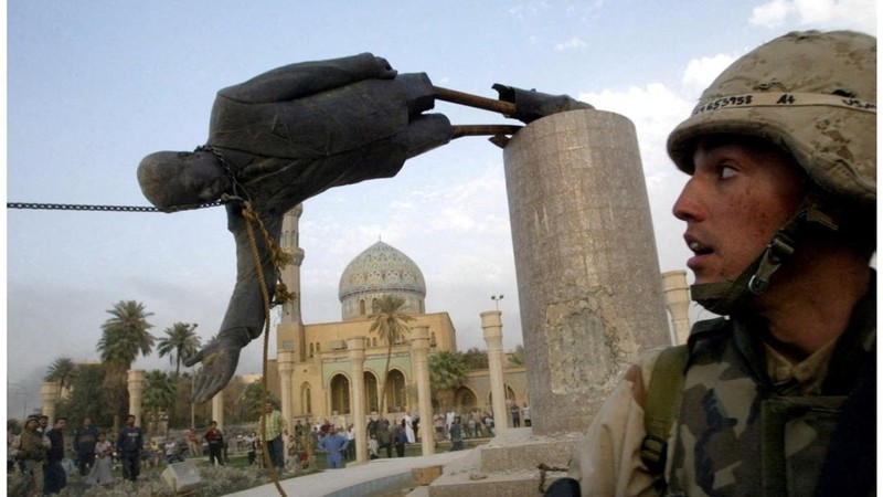 A combination picture shows a U.S. soldier watching as a statue of Iraqi President Saddam Hussein falls at Firdos Square in central Baghdad, Iraq, April 9, 2003, and the square on September 28, 2026.  REUTERS/Goran Tomasevic  REUTERS/Ahmed Saad     T