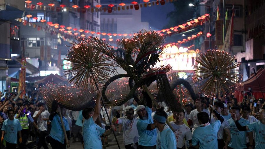 Para penampil berpartisipasi dalam Tari Naga Api Tai Hang yang telah berusia berabad-abadmenampilkan replika naga sepanjang 67 meter yang diterangi oleh ribuan batang dupa yang menyalamenjelang Festival Pertengahan Musim Gugur di Hong Kong, Tiongkok,
