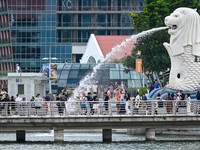 People gather around the Merlion statue at the Marina Bay waterfront in Singapore on May 13, 2024. (Photo by Roslan RAHMAN / AFP)
