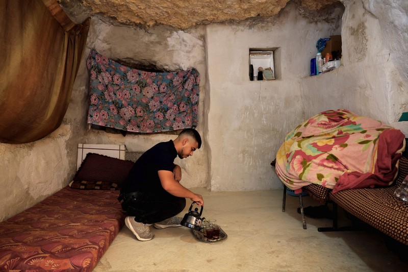 A Palestinian serves tea in a cave used as a house after Israeli forces demolished his house, in Masafer Yatta near Hebron in the Israeli-occupied West Bank, September 18, 2026. REUTERS/Mussa Qawasma