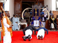 Orang-orang bersujud di hadapan Raja Edward Rukidi Nyabongo I dari Kerajaan Tooro saat ia duduk di takhtanya sebagai penguasa ke-13 bagi rakyat Batooro, pada hari penobatannya yang sarat dengan ritual di Istana Karuziika, Fort Portal, Uganda, tanggal