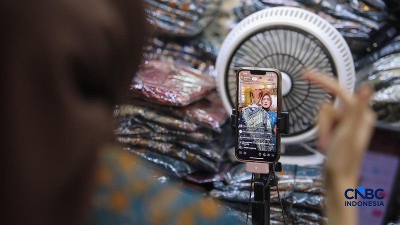 Pedagang melakukan siaran langsung saat menjual pakaian melalui aplikasi belanja daring (e-commerce) di Thamrin City, Jakarta, Rabu (30/9/2026).