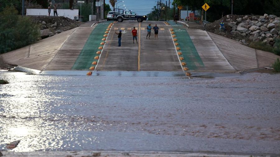 Warga berdiri di jalan yang tergenang air setelah Badai Polo menghantam daratan di Baja California Sur, Loreto, Meksiko, pada 29 September 2026.