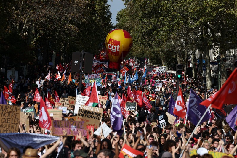 Petugas pemadam kebakaran Prancis membentangkan bendera Prancis saat unjuk rasa yang menuntut tambahan sumber daya dan pendanaan&mdash;menyusul musim panas yang diwarnai kebakaran hebat&mdash;di Paris sebagai bagian dari aksi mogok kerja dan protes oleh pekerja sektor publik di Prancis pada 29 September 2026. (REUTERS/Tom Nicholson)