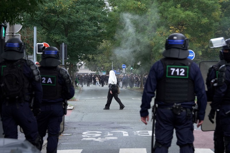 French CRS riot police stand in position in a street amid clashes during a protest by French high school and university students near Lycee Paul Eluard high-school to demand the hiring of substitute teachers, increased resources and better learning conditions, and to support the ongoing high-school student movement in the Seine-Saint-Denis department, in Saint-Denis near Paris, France, October 1, 2026.  REUTERS/Abdul Saboor