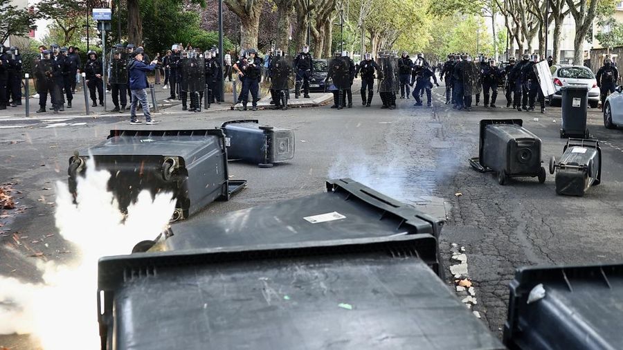 French CRS riot police stand in position in a street amid clashes during a protest by French high school and university students near Lycee Paul Eluard high-school to demand the hiring of substitute teachers, increased resources and better learning c