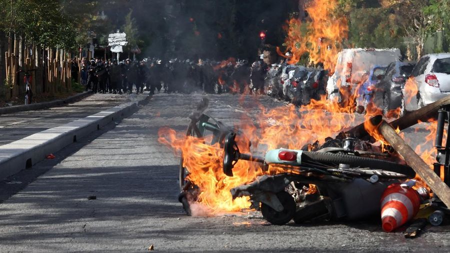 View of burning Velib bicycle, garbage bins and objects set up by high school and university students in a street amid clashes with French riot police during a student protest to demand the hiring of substitute teachers, increased resources and bette