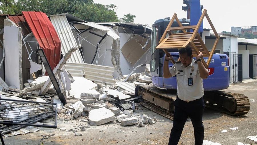An official carries away furniture from one of the "villas" in the Cibinong men's prison, where inmates allegedly paid rent for the luxury accommodation, during the demolition of the structures on the prison grounds in Bogor on September 30, 2026. In