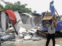 An official carries away furniture from one of the "villas" in the Cibinong men's prison, where inmates allegedly paid rent for the luxury accommodation, during the demolition of the structures on the prison grounds in Bogor on September 30, 2026. In