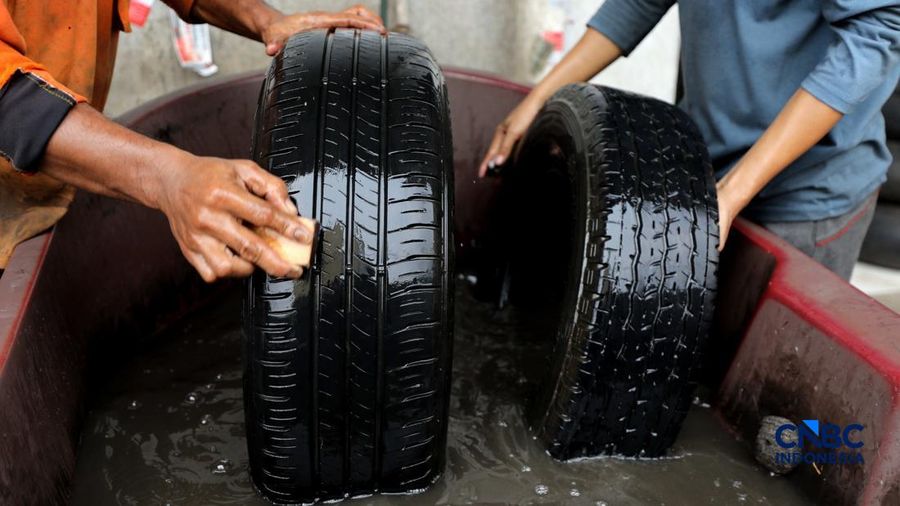 Pekerja mencuci ban bekas di sentra pengempul ban bekas di kawasan Sasak Panjang, Tajur Halang, Bogor, Jawa Barat, Kamis (1/10/2026). Tumpukan ban mobil bekas ini dibeli dari bengkel-bengkel ban wilayah Jabodetabek.  (CNBC Indonesia/Tri Susilo)