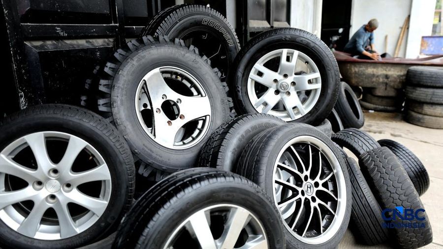 Pekerja mencuci ban bekas di sentra pengempul ban bekas di kawasan Sasak Panjang, Tajur Halang, Bogor, Jawa Barat, Kamis (1/10/2026). Tumpukan ban mobil bekas ini dibeli dari bengkel-bengkel ban wilayah Jabodetabek.  (CNBC Indonesia/Tri Susilo)