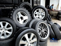 Pekerja mencuci ban bekas di sentra pengempul ban bekas di kawasan Sasak Panjang, Tajur Halang, Bogor, Jawa Barat, Kamis (1/10/2026). Tumpukan ban mobil bekas ini dibeli dari bengkel-bengkel ban wilayah Jabodetabek.  (CNBC Indonesia/Tri Susilo)
