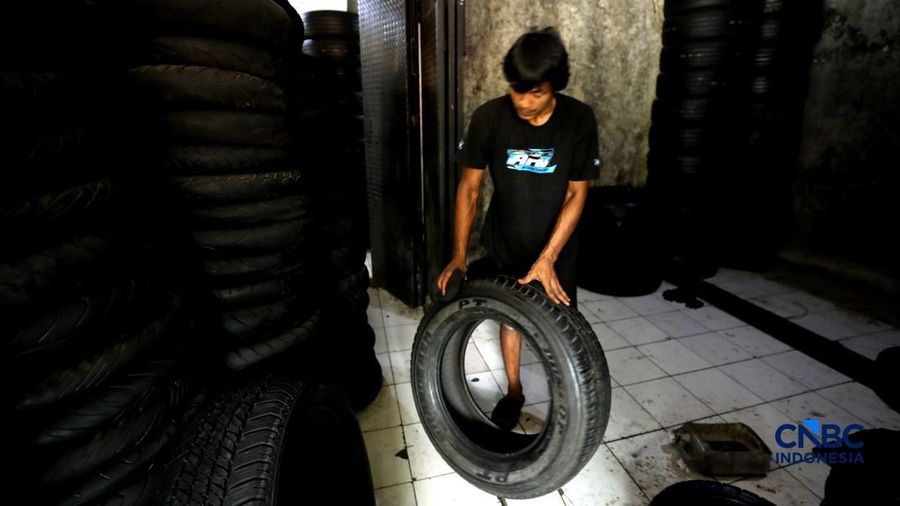 Pekerja mencuci ban bekas di sentra pengempul ban bekas di kawasan Sasak Panjang, Tajur Halang, Bogor, Jawa Barat, Kamis (1/10/2026). Tumpukan ban mobil bekas ini dibeli dari bengkel-bengkel ban wilayah Jabodetabek.  (CNBC Indonesia/Tri Susilo)