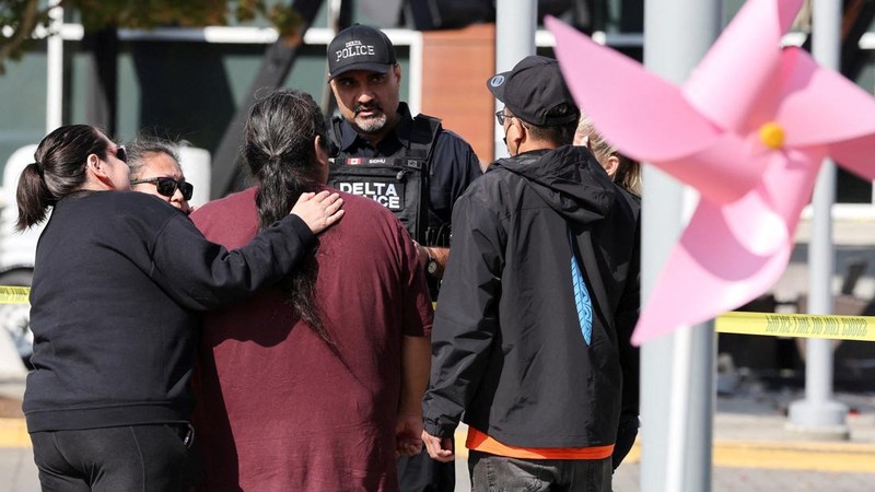 Seorang petugas kepolisian Delta berbicara dengan anggota komunitas First Nations setempat di lokasi kecelakaan di pusat perbelanjaan Tsawwassen Mills di Tsawwassen, British Columbia, Kanada, pada 30 September 2026.