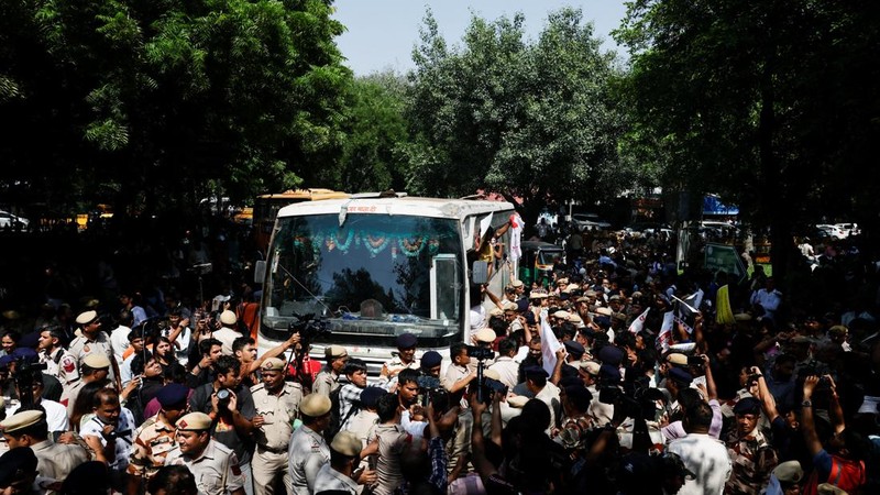 Para pengunjuk rasa meneriakkan slogan-slogan dari dalam kendaraan polisi setelah ditahan dalam aksi protes yang menuntut pengunduran diri Kepala Komisioner Pemilihan Umum India, Gyanesh Kumar, di New Delhi, India, pada 2 Oktober 2026. (REUTERS/Adnan