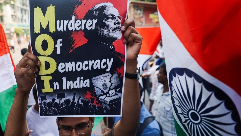 Seorang pengunjuk rasa memegang poster yang menampilkan gambar Perdana Menteri India Narendra Modi dalam sebuah aksi protes yang menuntut pengunduran diri Kepala Komisioner Pemilihan Umum India, Gyanesh Kumar, di Shivaji Park, Mumbai, India, pada 2 Oktober 2026.