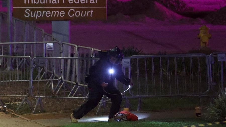 Seorang petugas polisi memeriksa sebuah tas menyusul dugaan ancaman bom di dekat Mahkamah Agung di Brasilia, Brasil, pada 1 Oktober 2026.