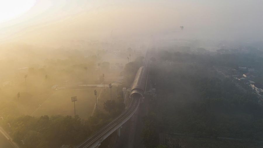 Foto udara dari drone memperlihatkan jalur Light Rail Transit (LRT) yang diselimuti kabut asap akibat kebakaran hutan di Palembang, Sumatra Utara, pada 3 September 2026. (AL ZULKIFLI / AFP)