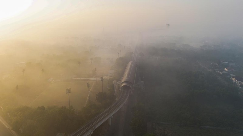 Foto udara dari drone memperlihatkan jalur Light Rail Transit (LRT) yang diselimuti kabut asap akibat kebakaran hutan di Palembang, Sumatra Utara, pada 3 September 2026. (AL ZULKIFLI / AFP)