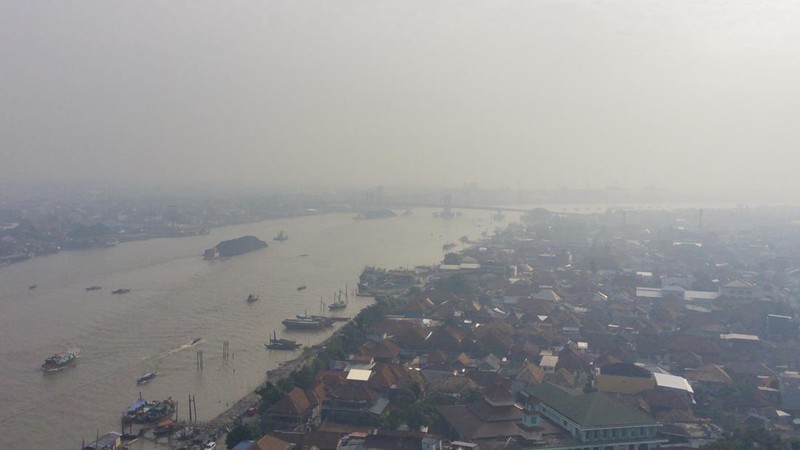 Foto udara memperlihatkan Sungai Musi di tengah kabut asap akibat kebakaran hutan dan lahan yang sedang berlangsung di Palembang, Sumatra Selatan, pada 14 September 2023. (Al ZULKIFLI / AFP)