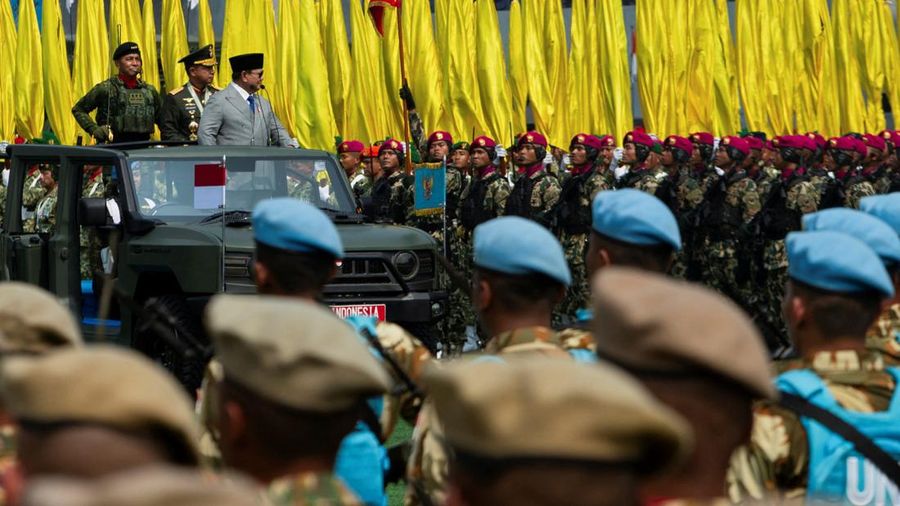 Presiden Indonesia Prabowo Subianto, didampingi oleh Panglima TNI Agus Subiyanto, berdiri di atas kendaraan militer saat memeriksa pasukan dalam upacara peringatan HUT ke-81 Tentara Nasional Indonesia (TNI) di Markas Besar TNI di Jakarta, pada 5 Okto