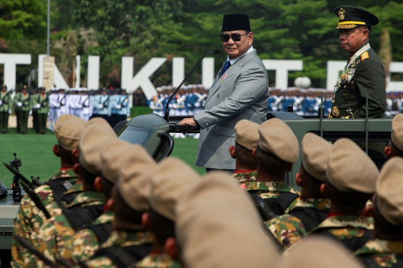 Presiden Indonesia Prabowo Subianto, didampingi oleh Panglima TNI Agus Subiyanto, berdiri di atas kendaraan militer saat memeriksa pasukan dalam upacara peringatan HUT ke-81 Tentara Nasional Indonesia (TNI) di Markas Besar TNI di Jakarta, pada 5 Oktober 2026. (REUTERS/Claudio Pramana0