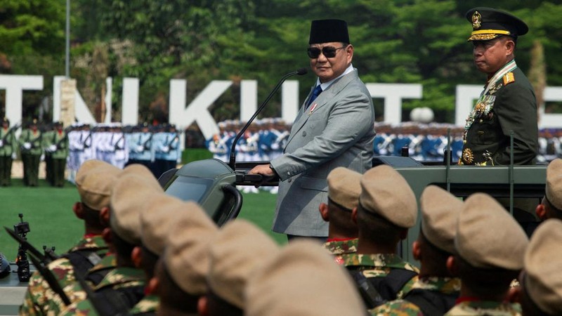 Presiden Indonesia Prabowo Subianto, didampingi oleh Panglima TNI Agus Subiyanto, berdiri di atas kendaraan militer saat memeriksa pasukan dalam upacara peringatan HUT ke-81 Tentara Nasional Indonesia (TNI) di Markas Besar TNI di Jakarta, pada 5 Oktober 2026.