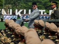 Presiden Indonesia Prabowo Subianto, didampingi oleh Panglima TNI Agus Subiyanto, berdiri di atas kendaraan militer saat memeriksa pasukan dalam upacara peringatan HUT ke-81 Tentara Nasional Indonesia (TNI) di Markas Besar TNI di Jakarta, pada 5 Okto