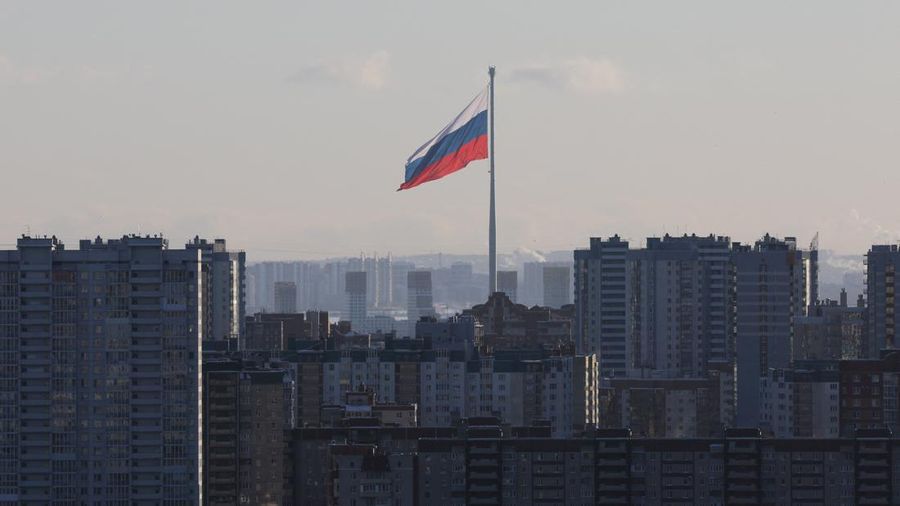 Sebuah bendera nasional Rusia berukuran raksasa berkibar di belakang blok-blok apartemen di Saint Petersburg, Rusia, pada 19 Februari 2025. (REUTERS/Anton Vaganov/File Foto)