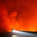 Seorang pengendara melintasi jalan saat kebakaran hutan dan lahan berkobar di dekat jalan utama di Ogan Ilir, Provinsi Sumatra Selatan, Indonesia, 11 September 2026. (REUTERS/Abriansyah Liberto)