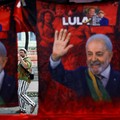 Seseorang berjalan di belakang deretan kaus yang menampilkan gambar Presiden Brasil sekaligus kandidat yang mencalonkan diri kembali dari Partai Pekerja (PT), Luiz Inacio Lula da Silva, setelah pemungutan suara pemilihan umum Brasil berakhir di Rio d
