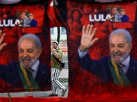Seseorang berjalan di belakang deretan kaus yang menampilkan gambar Presiden Brasil sekaligus kandidat yang mencalonkan diri kembali dari Partai Pekerja (PT), Luiz Inacio Lula da Silva, setelah pemungutan suara pemilihan umum Brasil berakhir di Rio d