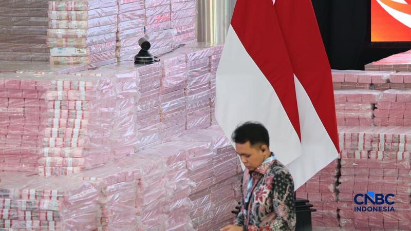 Pekerja berdiri di depan Tumpukan uang sekitar Rp132,241,335,681,910,13 dipajang dalam kegiatan penyerahan denda administratif dan penyelamatan keuangan negara serta penguasaan kembali kawasan hutan di kompleks Kejaksaan Agung, Jakarta, Selasa (06/10