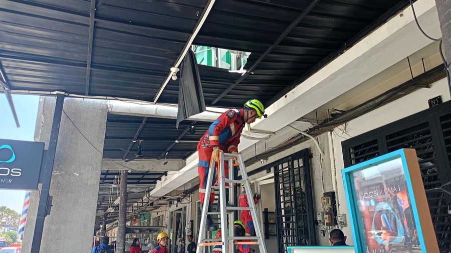 Sejumlah karyawan ruko dibantu petugas rescue BPBD Surabaya membersihkan pecahan kaca imbas leadakan di Pakuwon City, Surabaya, Selasa (6/10/2026).