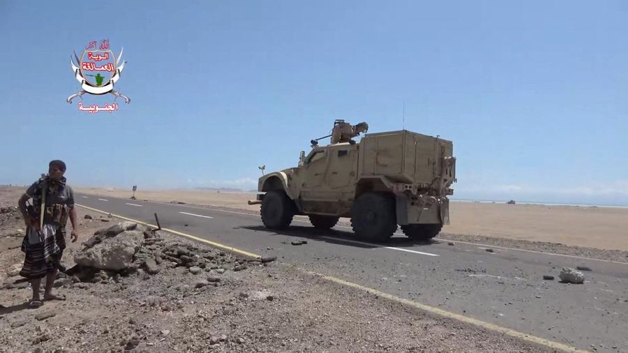 Seorang pejuang pemerintah Yaman yang didukung Arab Saudi berdiri di tepi jalan saat sebuah kendaraan militer melintas, dalam sebuah operasi yang menurut pasukan pemerintah merupakan upaya maju melawan kelompok Houthi yang didukung Iran, di dekat Dhu